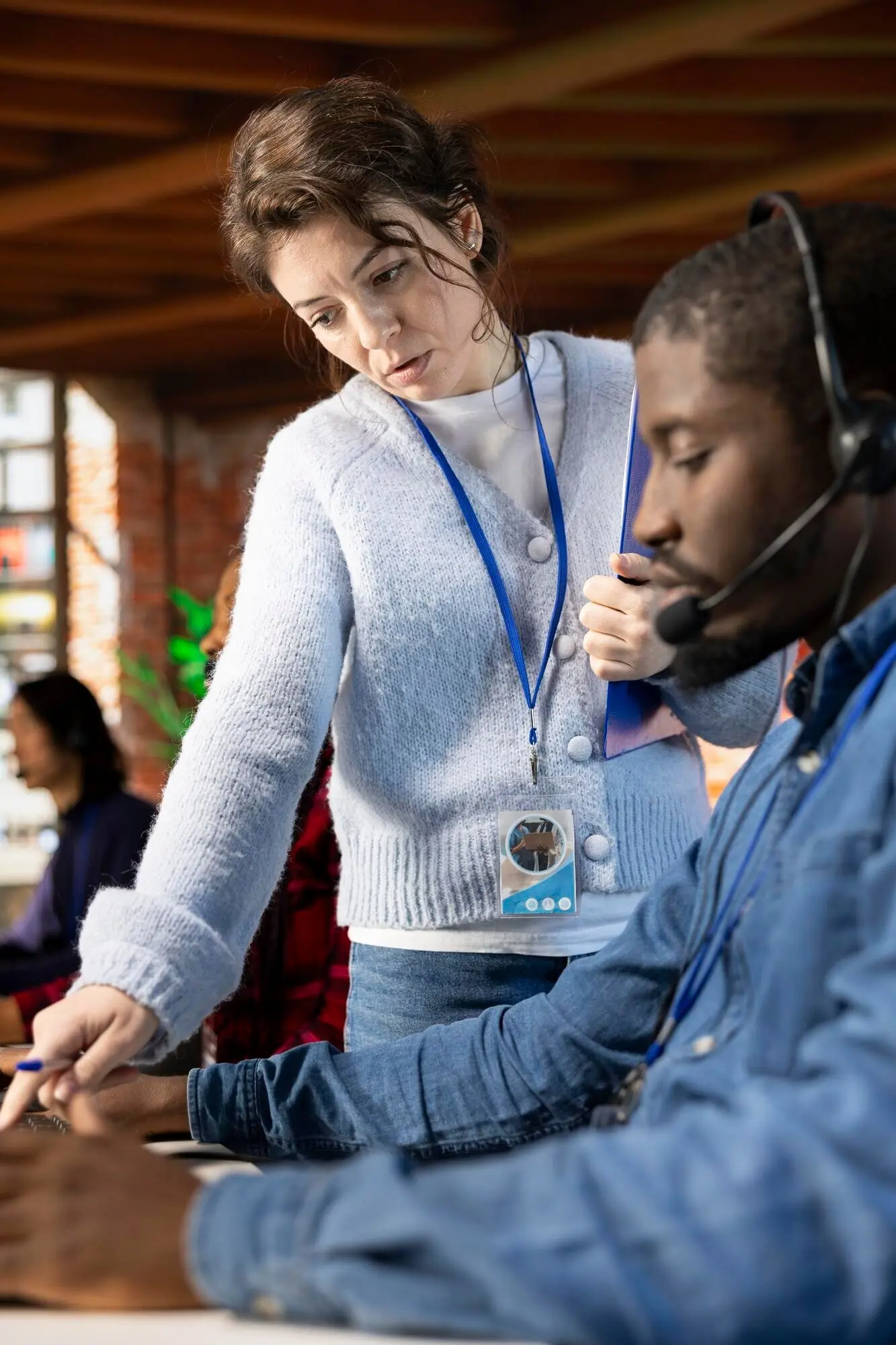 Крупный план: менеджер колл-центра дает наставления стажеру.