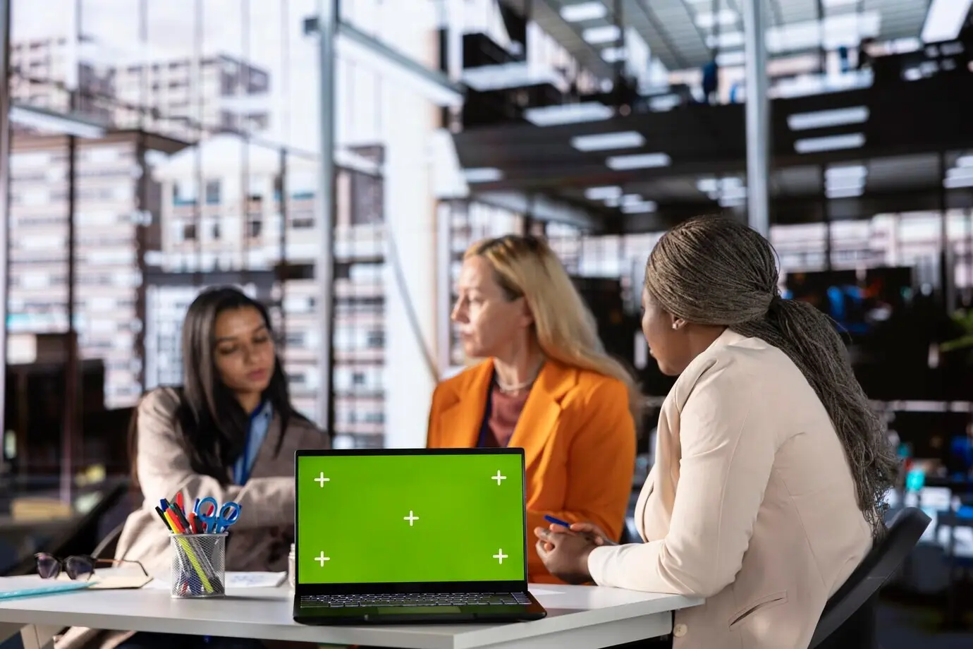 Разнообразная группа коллег-женщин, обеспечивающих достижение целей, рядом с хромакеем.